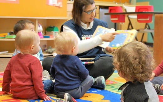 a person reading a book to several children