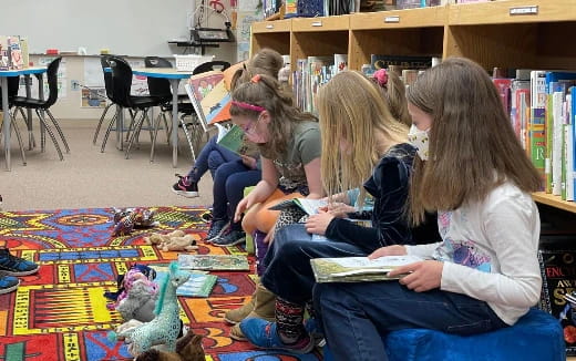 a group of people sitting on the floor reading books