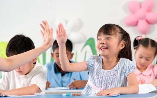 a group of children raising their hands