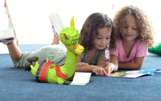 a couple of children sitting on the floor with a stuffed animal