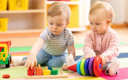 a couple of babies playing with toys