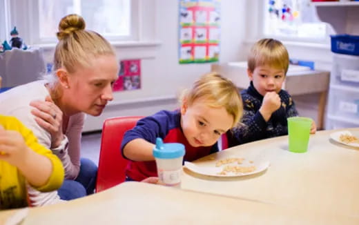 a group of kids eating at a table