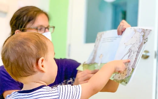 a person reading a book to a young boy