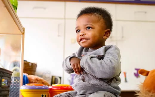 a baby standing in a kitchen