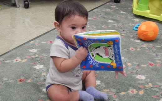 a baby holding a book