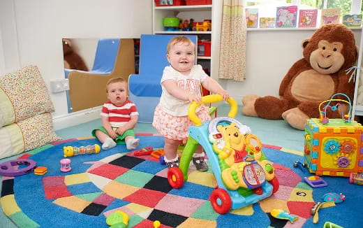 a couple of children sitting on the floor next to toys