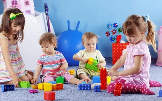 a group of children sitting on the floor playing with toys