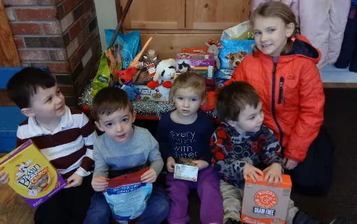 a group of children sitting on the floor with presents