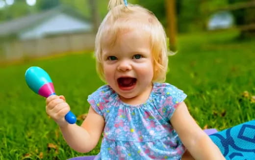 a baby girl holding a toy