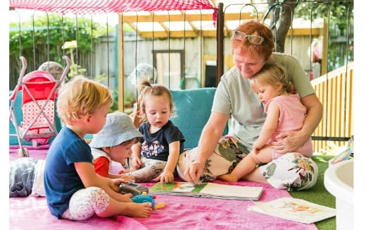 a person and kids sitting on a blanket on a blanket