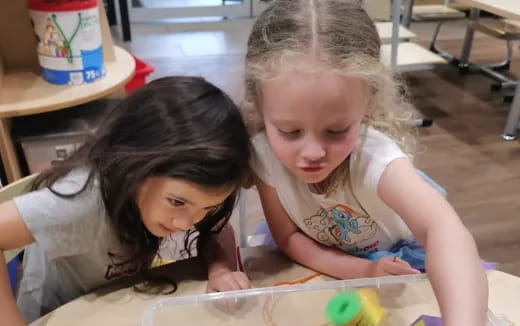 a couple of young girls coloring