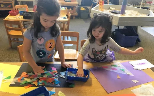 a couple of young girls playing with toys on a table