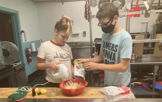 a couple of people preparing food