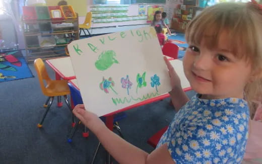 a girl holding a drawing