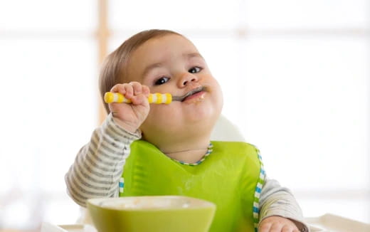 a baby eating corn