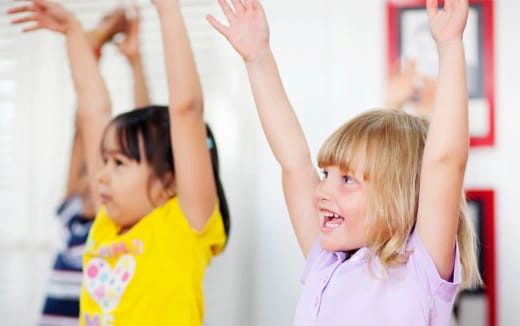 a few young girls raising their hands