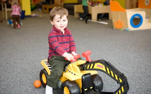 a child sitting on a toy car