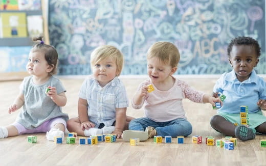 a group of children sitting on the floor playing with toys
