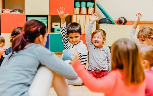 a group of children raising their hands