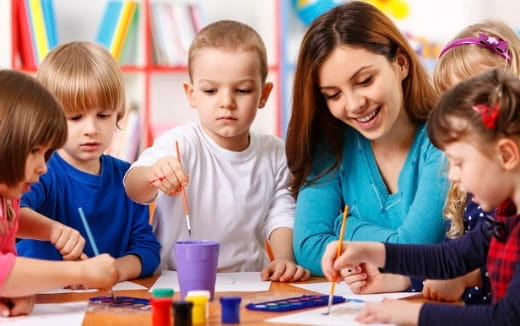 a person and several children painting