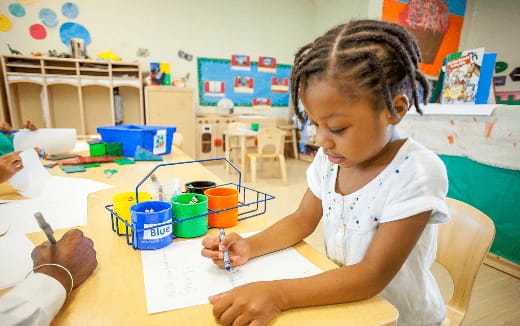 a young girl writing on a paper