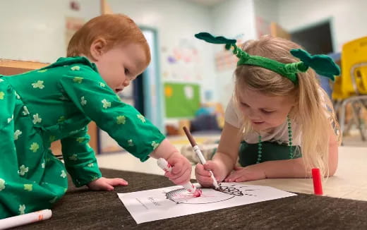 a couple of children writing on paper