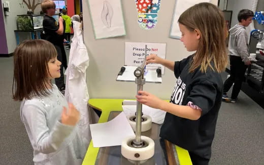 a person showing a girl something on a paper