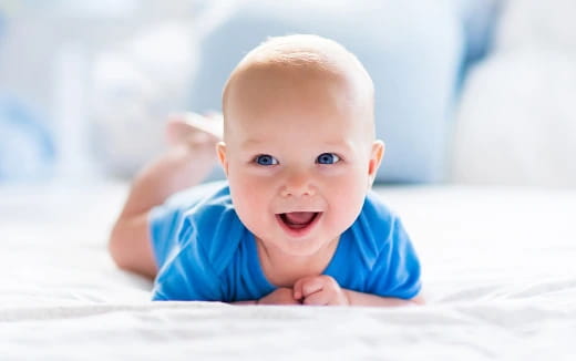 a baby lying on a bed