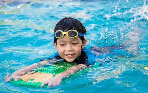 a boy wearing goggles in a pool