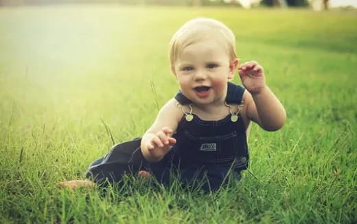 a baby lying in the grass