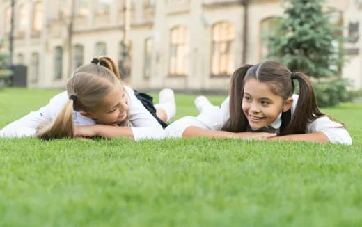 a couple of girls lying in the grass