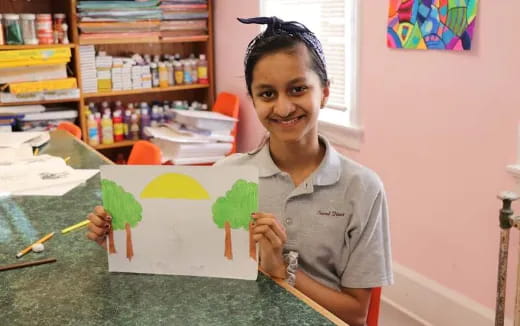 a girl holding a drawing