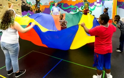 a group of people playing on a large colorful slide