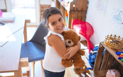 a girl holding a teddy bear