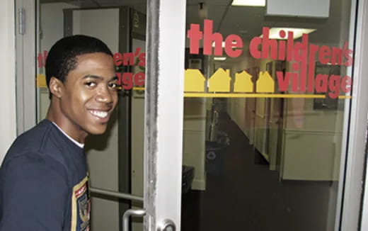 a man smiling in front of a glass door