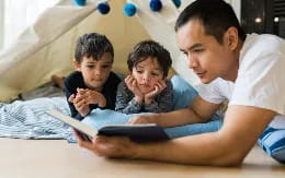 a person and a couple of children looking at a book