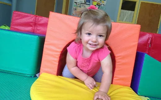 a girl sitting in a ball pit