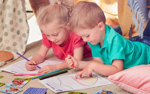 a couple of children coloring on paper