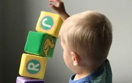 a child holding a yellow and green toy