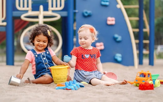 a couple of children playing in the sand