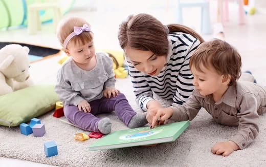 a person and two children playing with toys on the floor