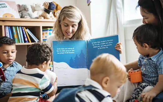 a person reading a book to a group of children