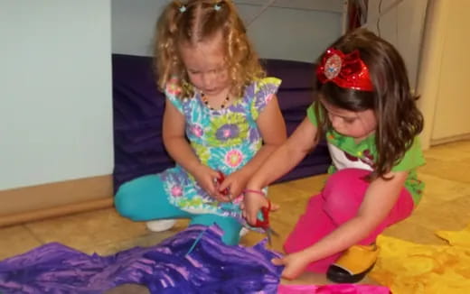 a couple of young girls playing with a toy