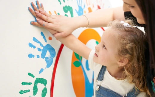 a young girl drawing on a white board