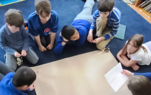 a group of children writing on paper