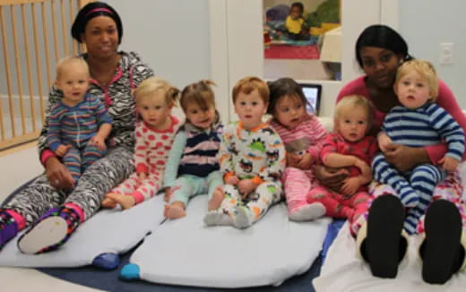 a group of children sitting on a bed