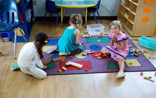 a group of children playing on a mat in a room