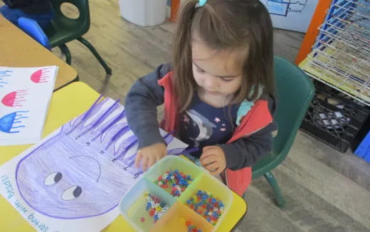 a girl coloring on a paper