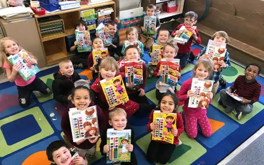 a group of children sitting on the floor holding books