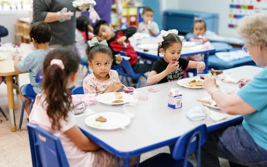 a group of children eating at a table